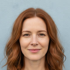 Test photo for example 2: an AI-generated red-haired woman around forty with freckles, looking at the camera with a slight smile